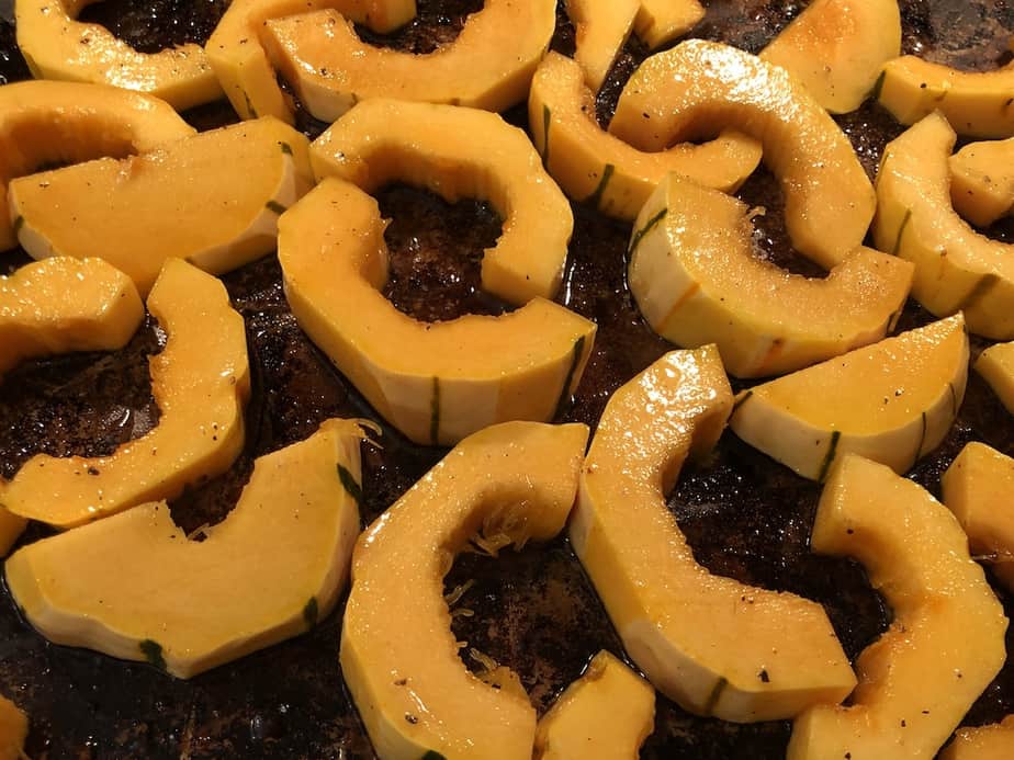 sliced delicata squash on a sheet pan