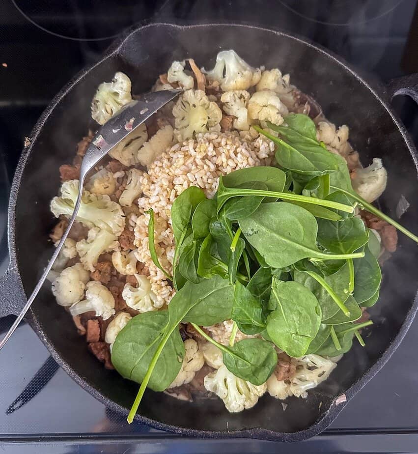 Cooked brown rice and spinach added to cauliflower skillet.