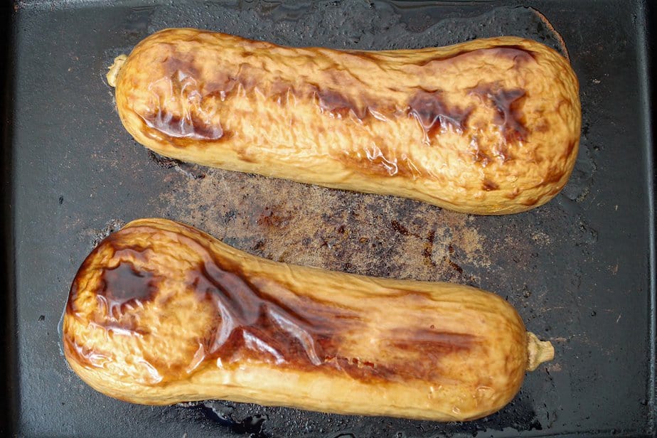 Two roasted halves of butternut squash on a baking sheet.