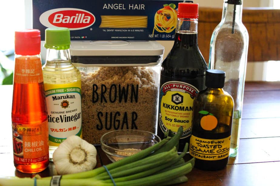 Ingredients for sesame noodle, chili oil, rice vinegar, brown sugar, angel hair pasta, soy sauce, olive oil, sesame oil, garlic and green onions.