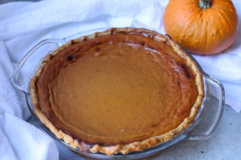 Cooked Pumpkin Pie with Honey with a small pumpkin to the right top of the photo.