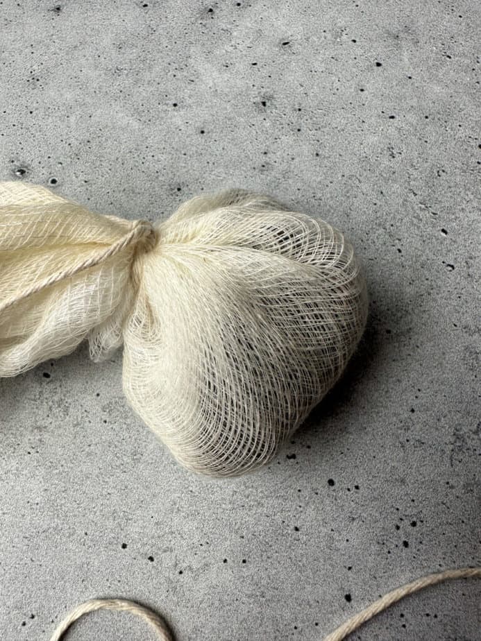 Spices in cheesecloth tied together with string so that it forms a pouch.