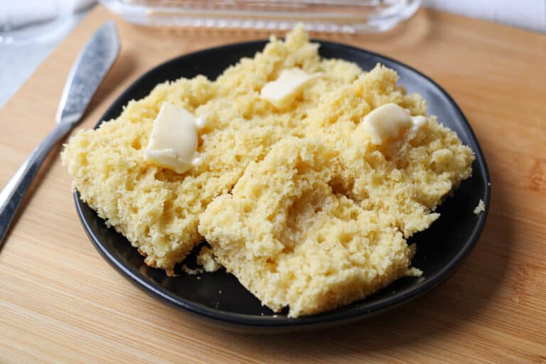 Sliced buttered cornbread on a plate.