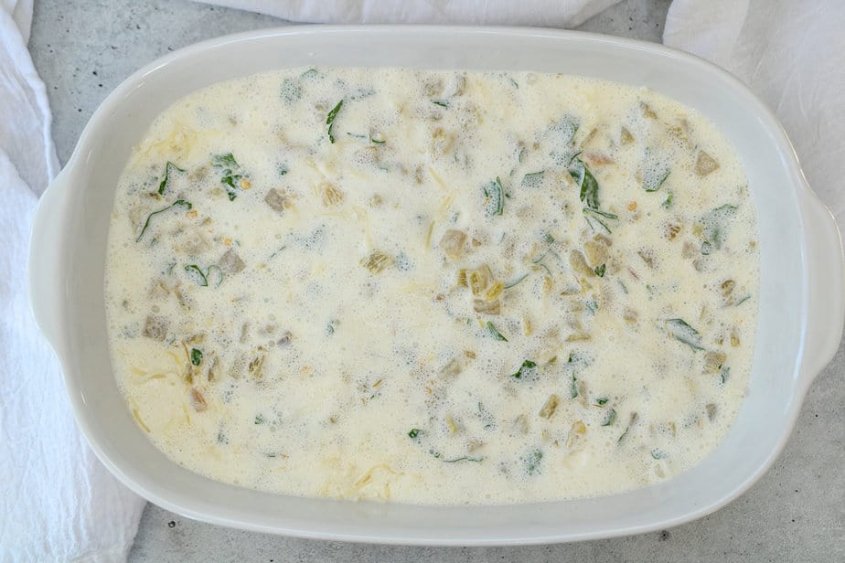 Creamy plant-based chicken in white baking dish with cream sauce added.