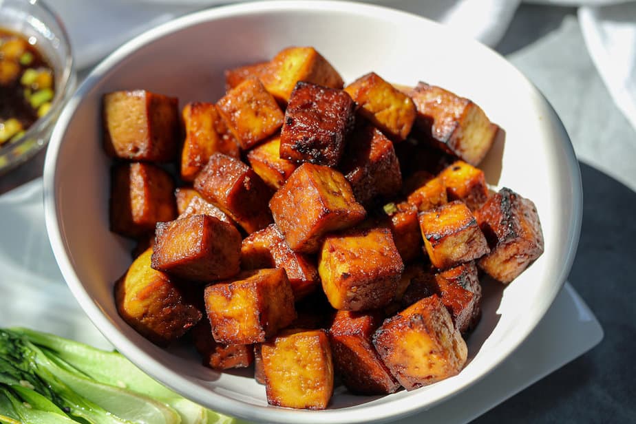 Cubed tofu that is crispy brown in white bowl.