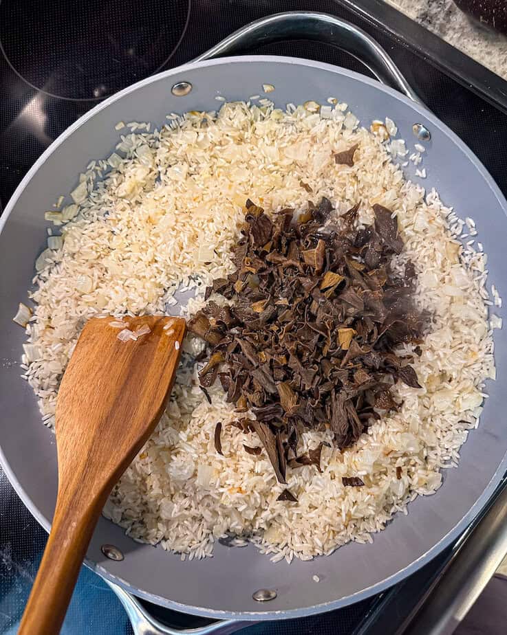 Black trumpet mushrooms and garlic added to pan.
