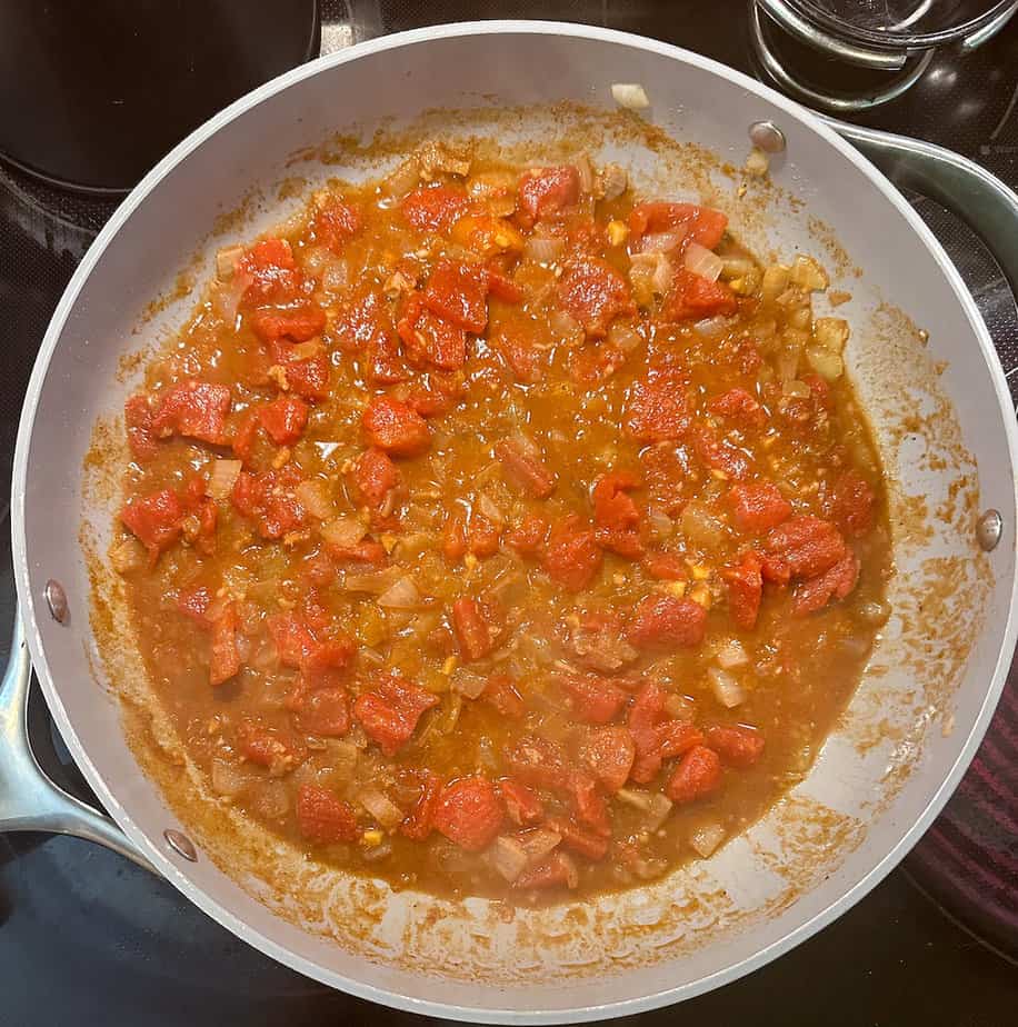 Chunky red sauce cooking in deep skillet.