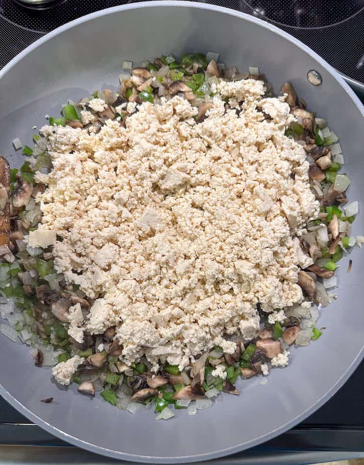 Large skillet with crumbled tofu and sautéed vegetables. 