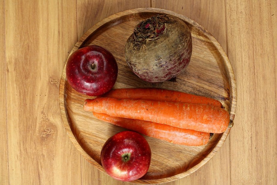 ingredients for beet and carrot juice: one large beet, three carrots, and two red apples.
