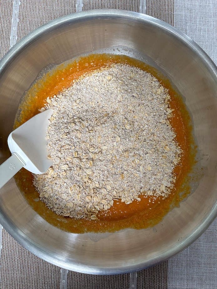 Dry ingredients added to wet ingredients in metal bowl.