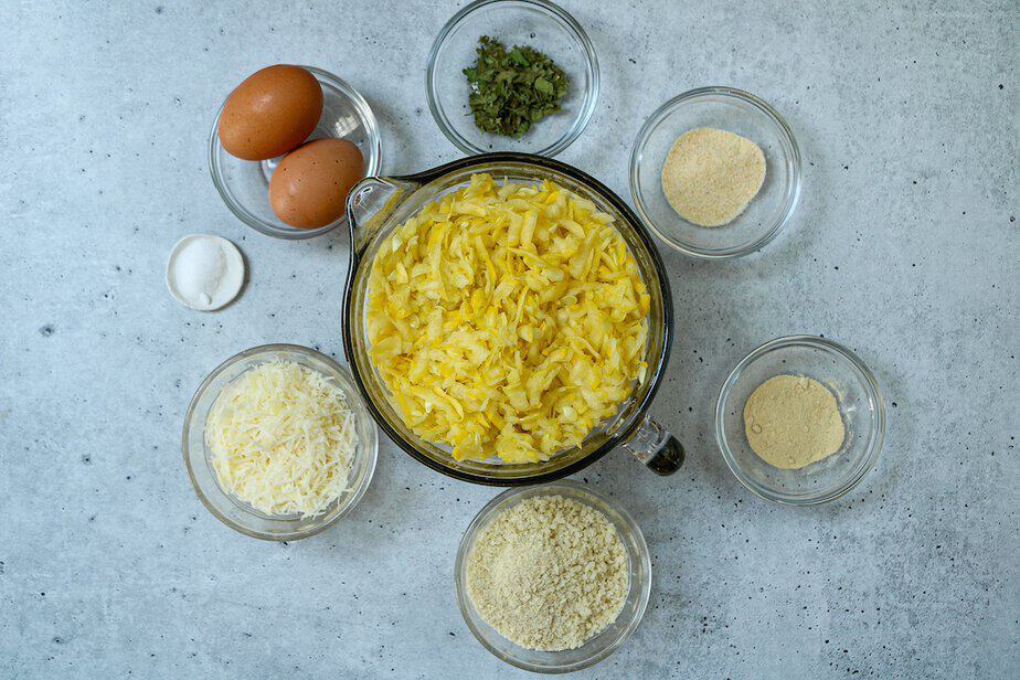 Ingredients for summer squash bites,  shredded summer squash, herbs, garlic and onion powder, bread crumbs, parmesan cheese, salt and two eggs.