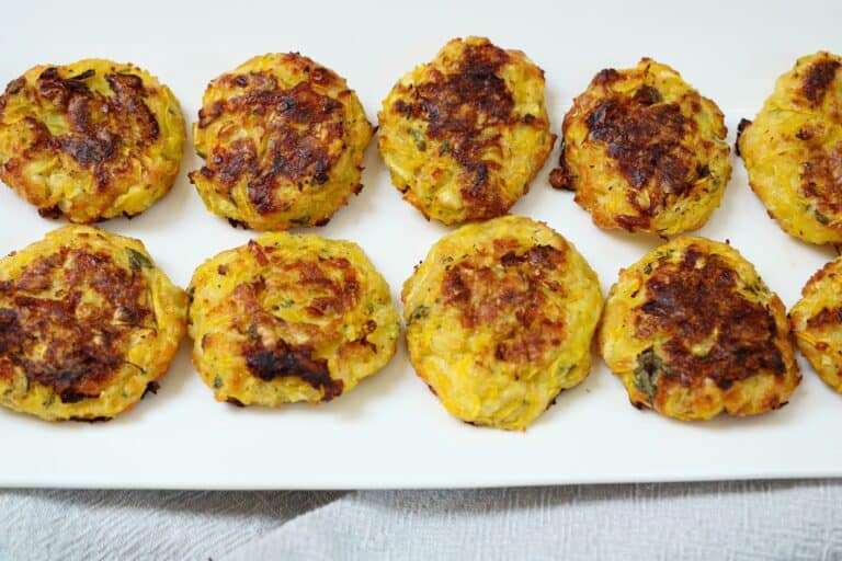 Cooked yellow summer squash bites on a white plate.