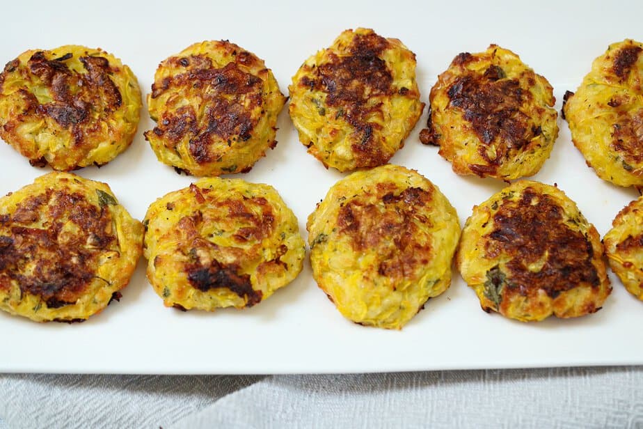 Cooked yellow summer squash bites on a white plate.