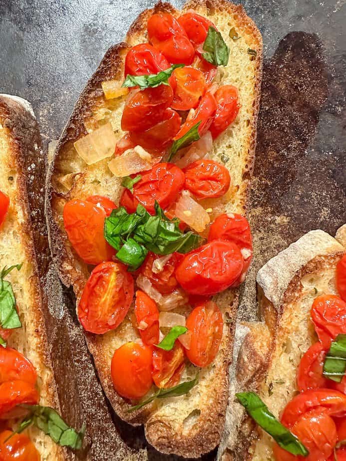 Roasted cherry tomato bruschetta on bread.