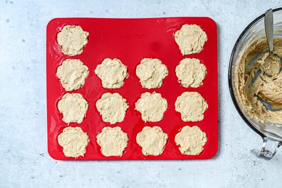 Frozen dog treats in a red silicone mold before freezing.