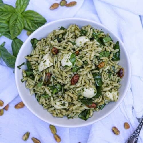Orzo salad with pesto, mozzarella balls, pistachios and greens mixed in.