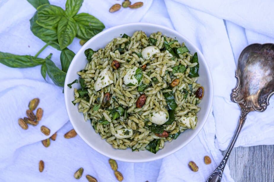 Orzo salad with pesto, mozzarella balls, pistachios and greens mixed in.