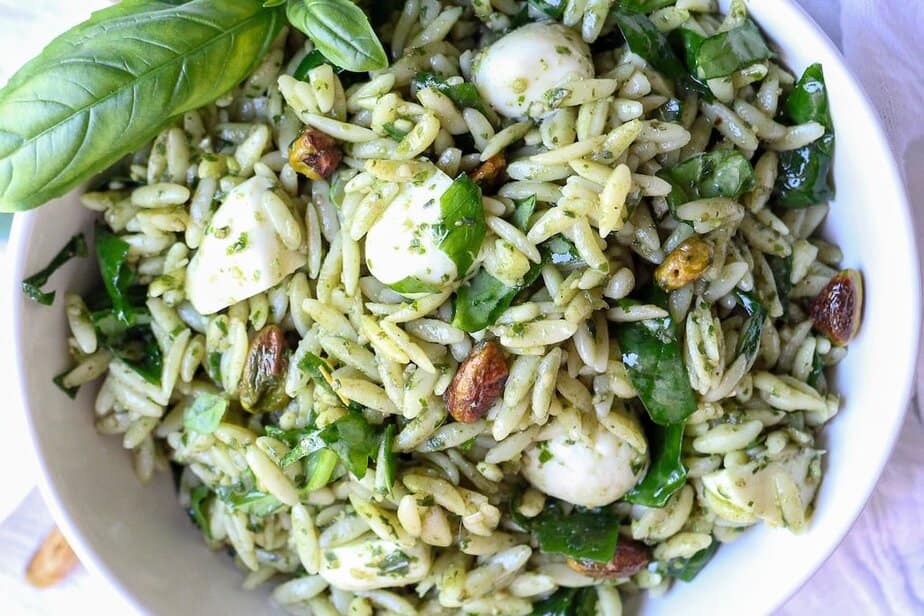Orzo salad with pesto, mozzarella balls, pistachios and greens mixed in.