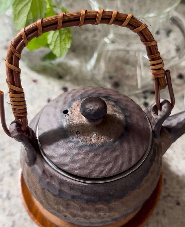 Teapot with cover on while tea leaves steep.