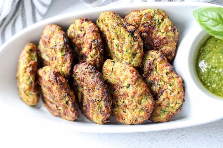 Pesto zucchini fritters on a white dish
