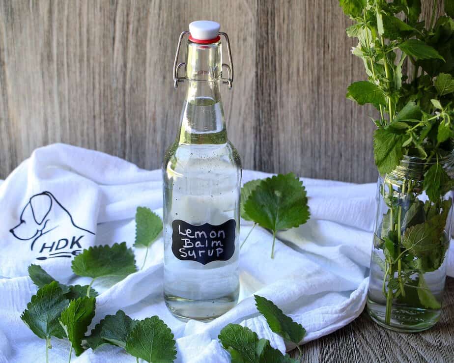 Lemon Balm Syrup in a glass jar with a flip-top lid.