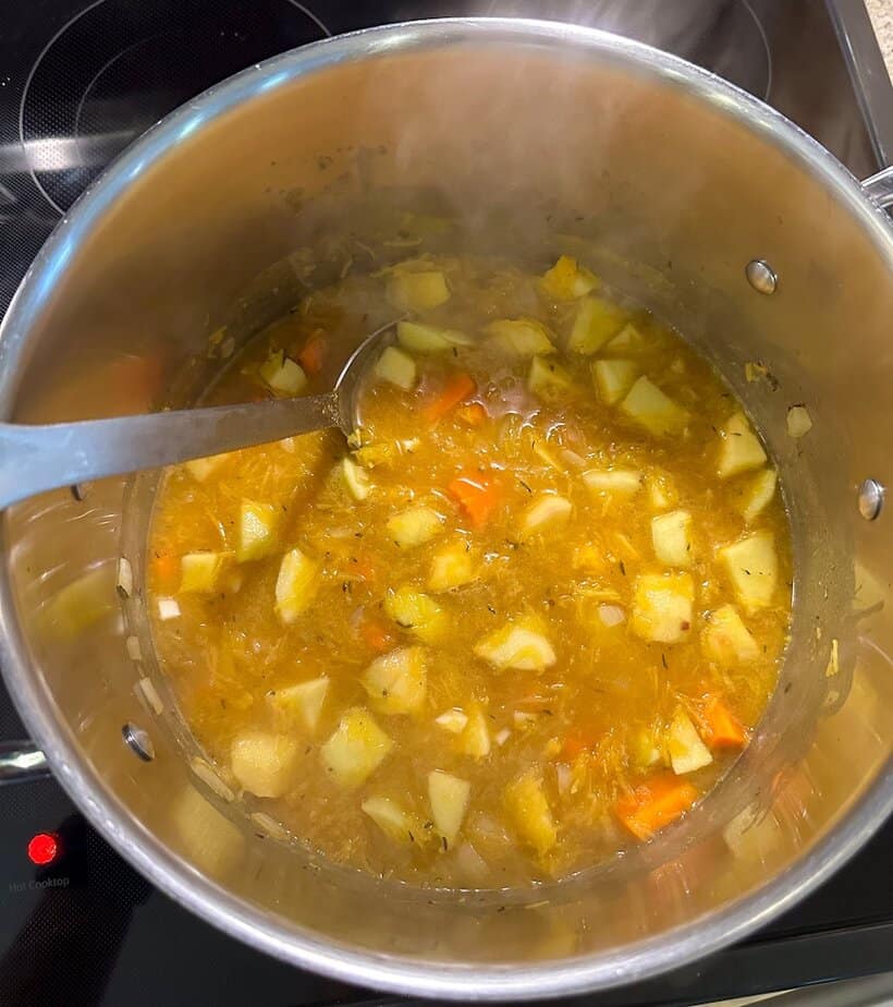 Pumpkin soup simmering in pot.