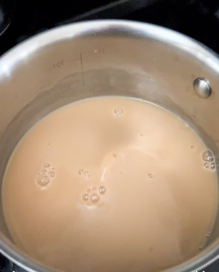Chai latte warming in a saucepan.