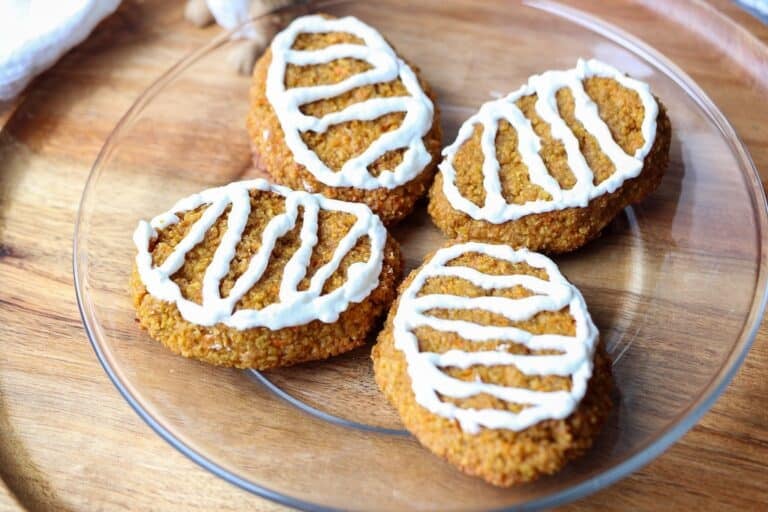 Frosted carrot treats on a plate.