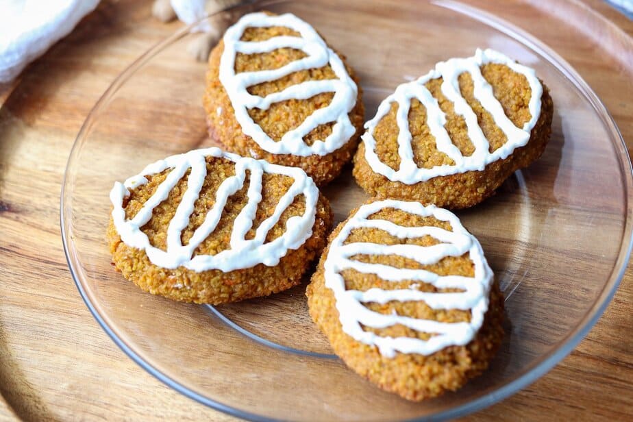 Frosted carrot treats on a plate.