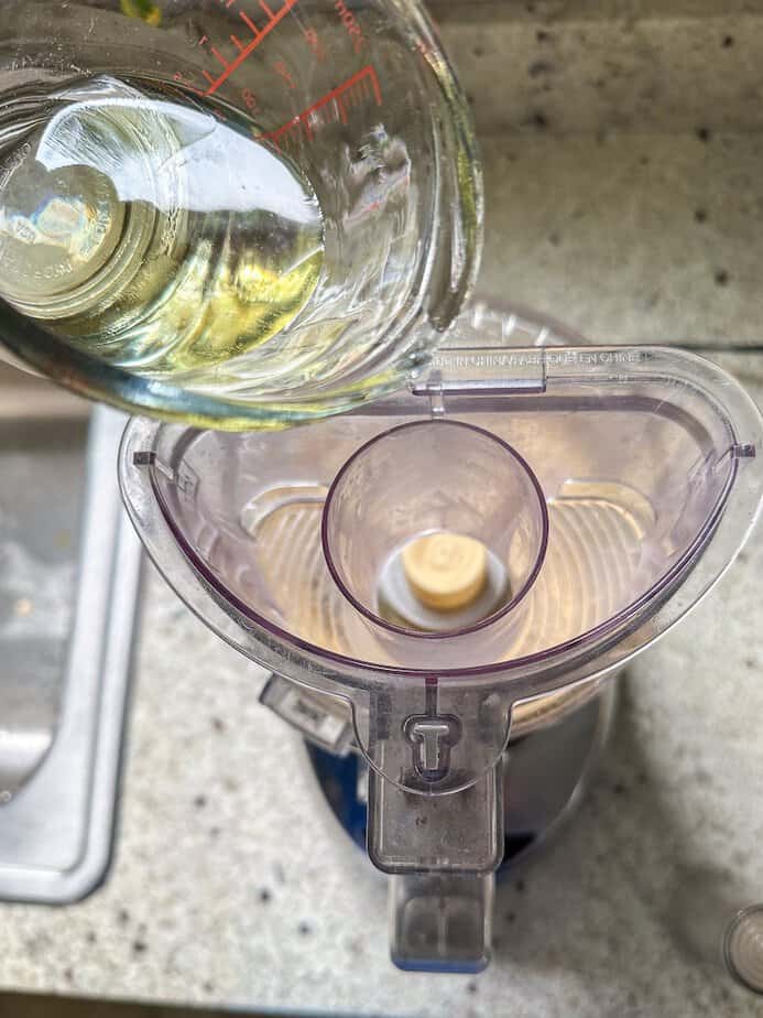 Oil pouring through shoot of a food processor.