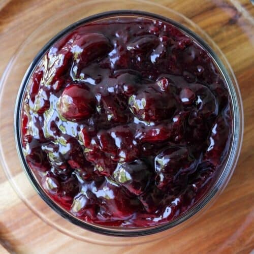 Cherry pie filling in a clear bowl.
