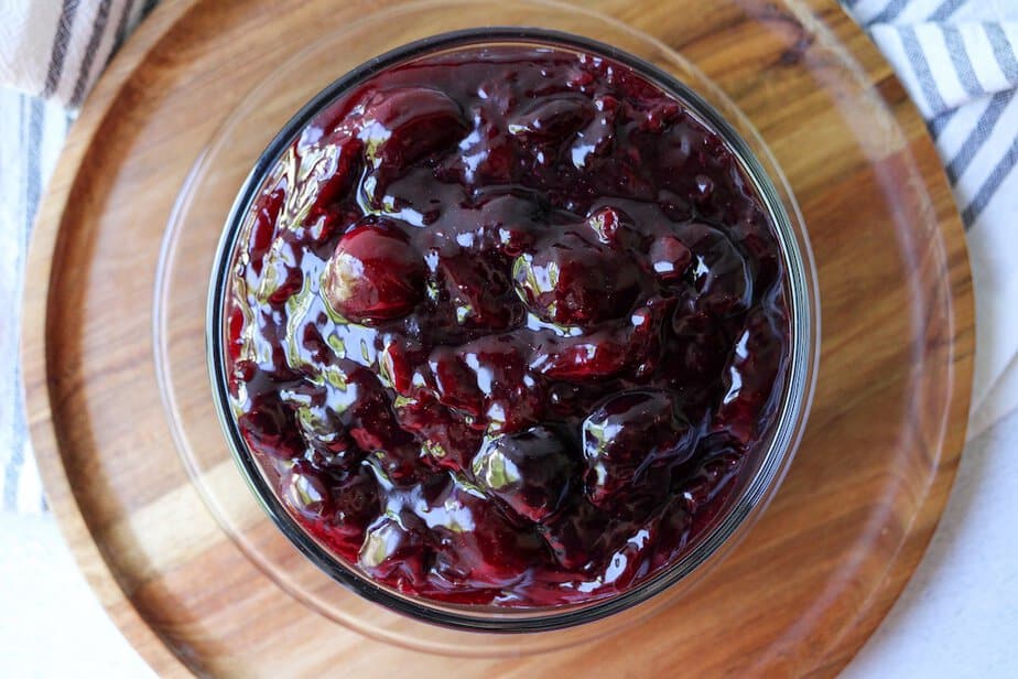 Cherry pie filling in a clear bowl.