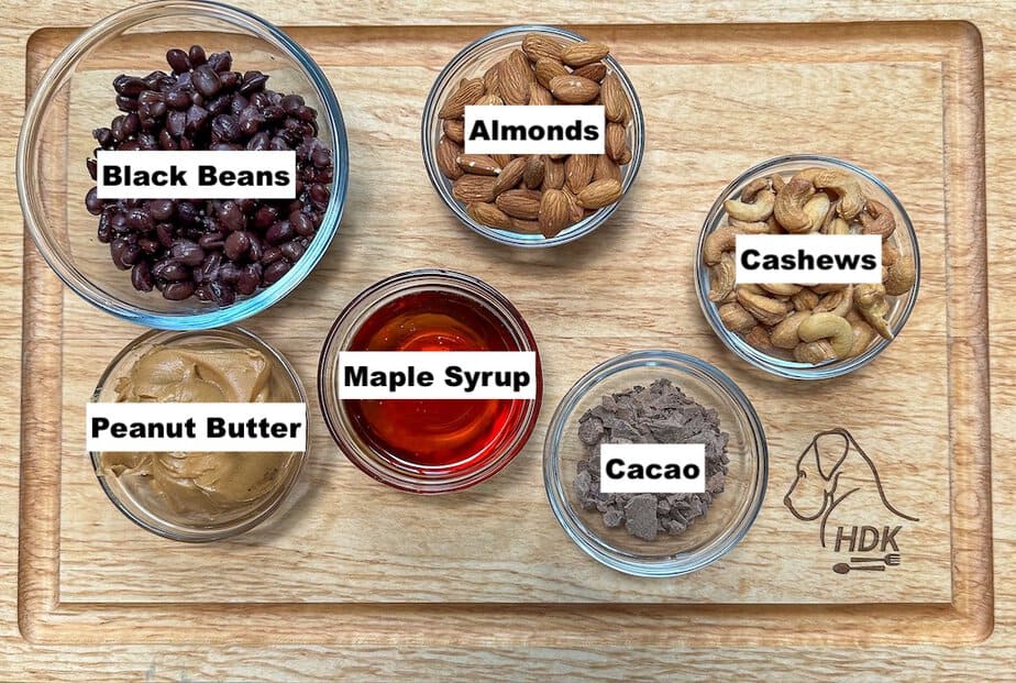Labeled ingredients in individual bowls for black bean peanut butter brownie bites.