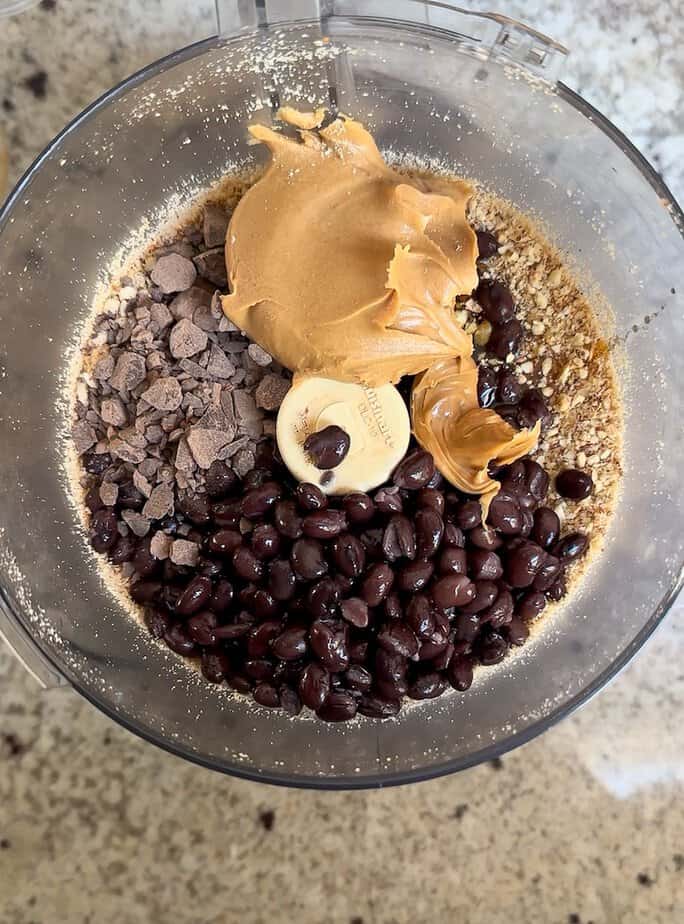 Ingredients for black bean brownie bites in food processor bowl.