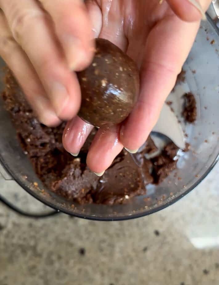 Hand rolling brownie bite to form a ball.