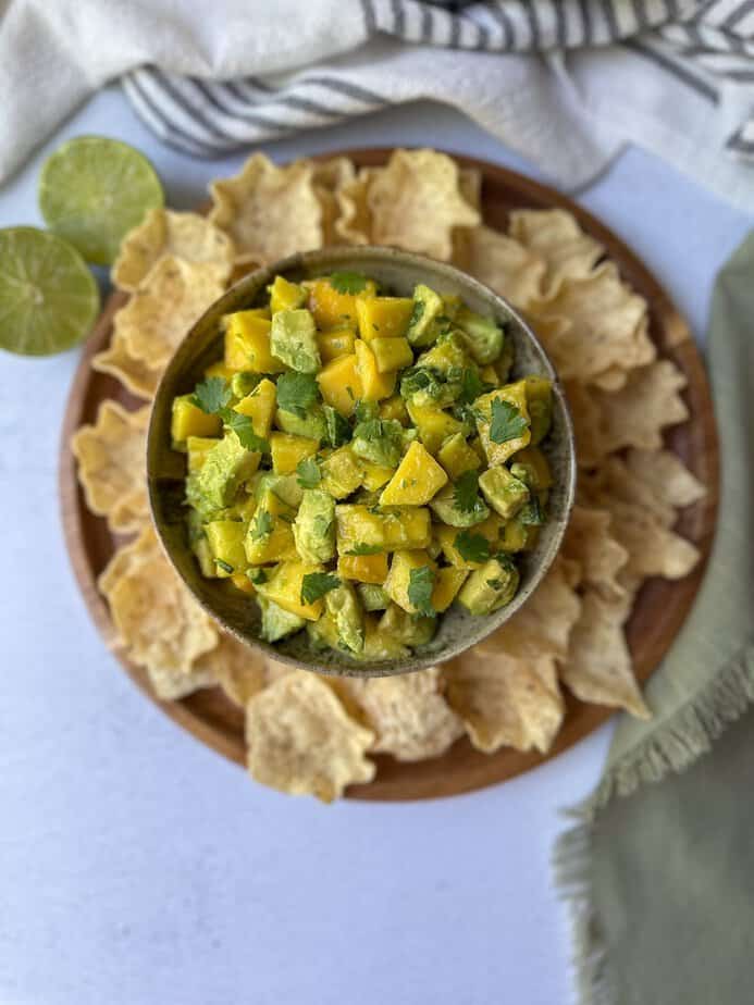 Fresh avocado and mango salsa in a serving bowl with tortilla chips.