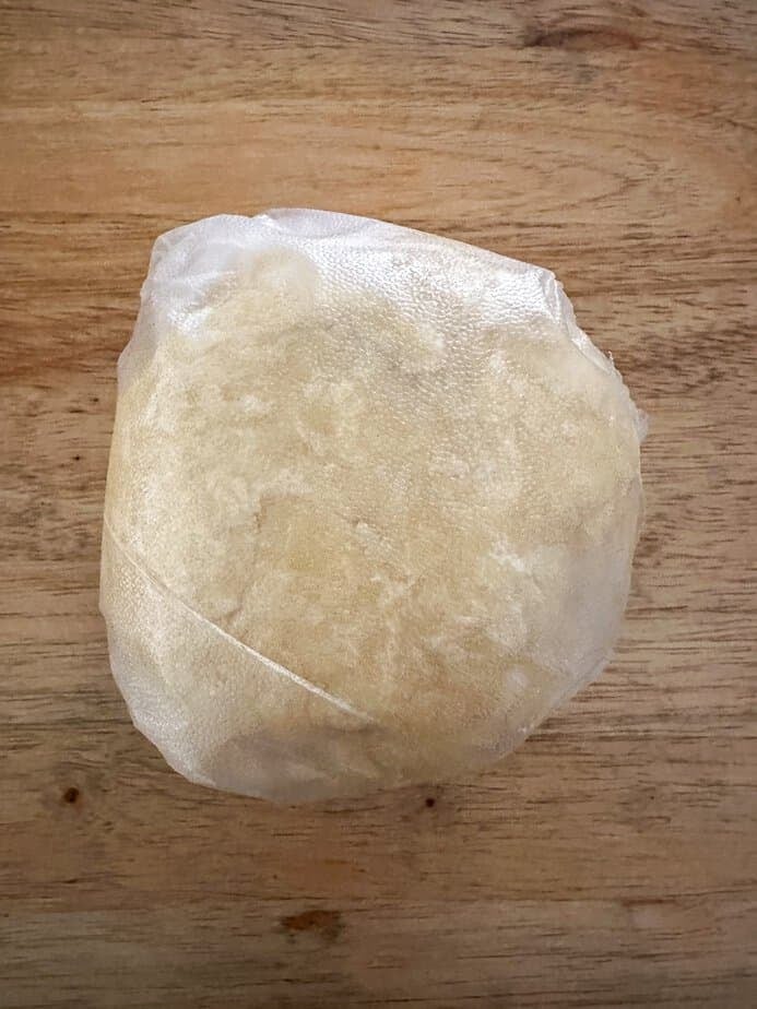 Sour cream pie crust dough wrapped in plastic wrap.