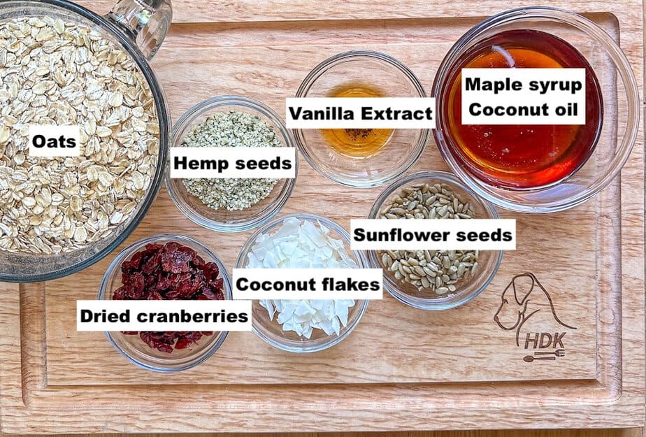 Labeled ingredients for granola with coconut and cranberries that are in individual bowls.