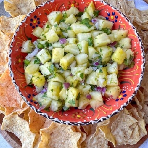 Pineapple Salsa in a festive bowl surround with tortilla chips.