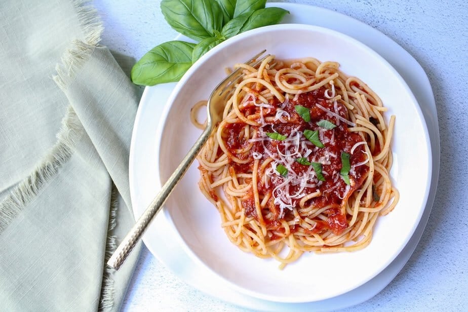 Slow cooker spaghetti sauce over spaghetti noodles on a plate.