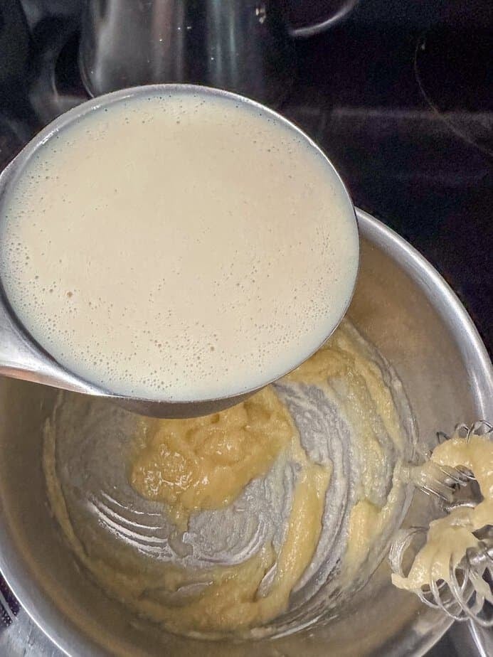 Milk being added to roux in saucepan.