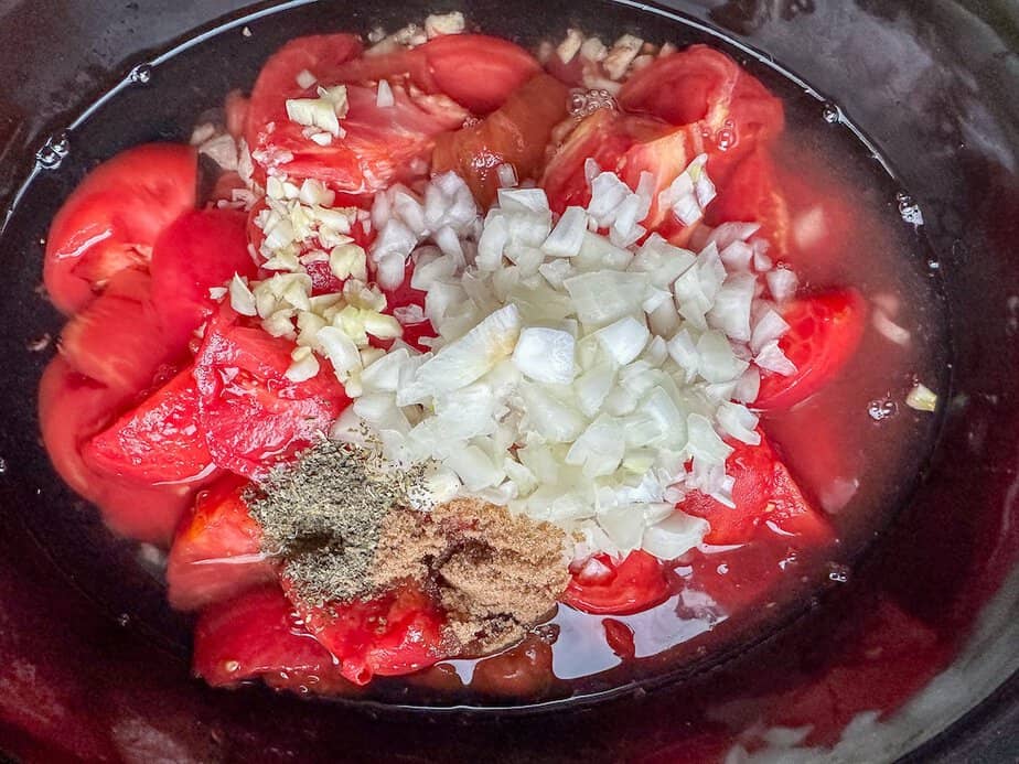 Ingredients for tomato soup in crockpot base.