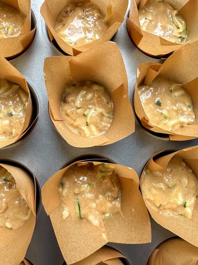 Sourdough Zucchini Muffin batter in baking cups before baking.