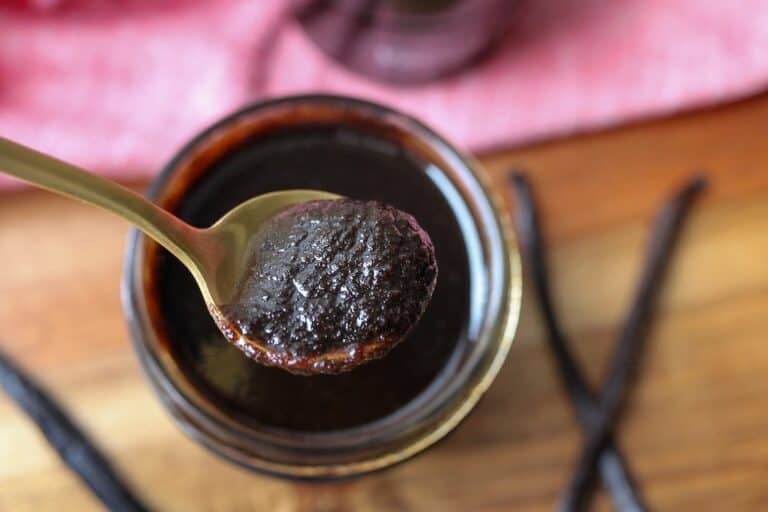 Spoon scooping vanilla bean paste.